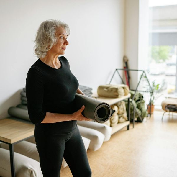 Person holding a balancing yoga pose in a bright studio.